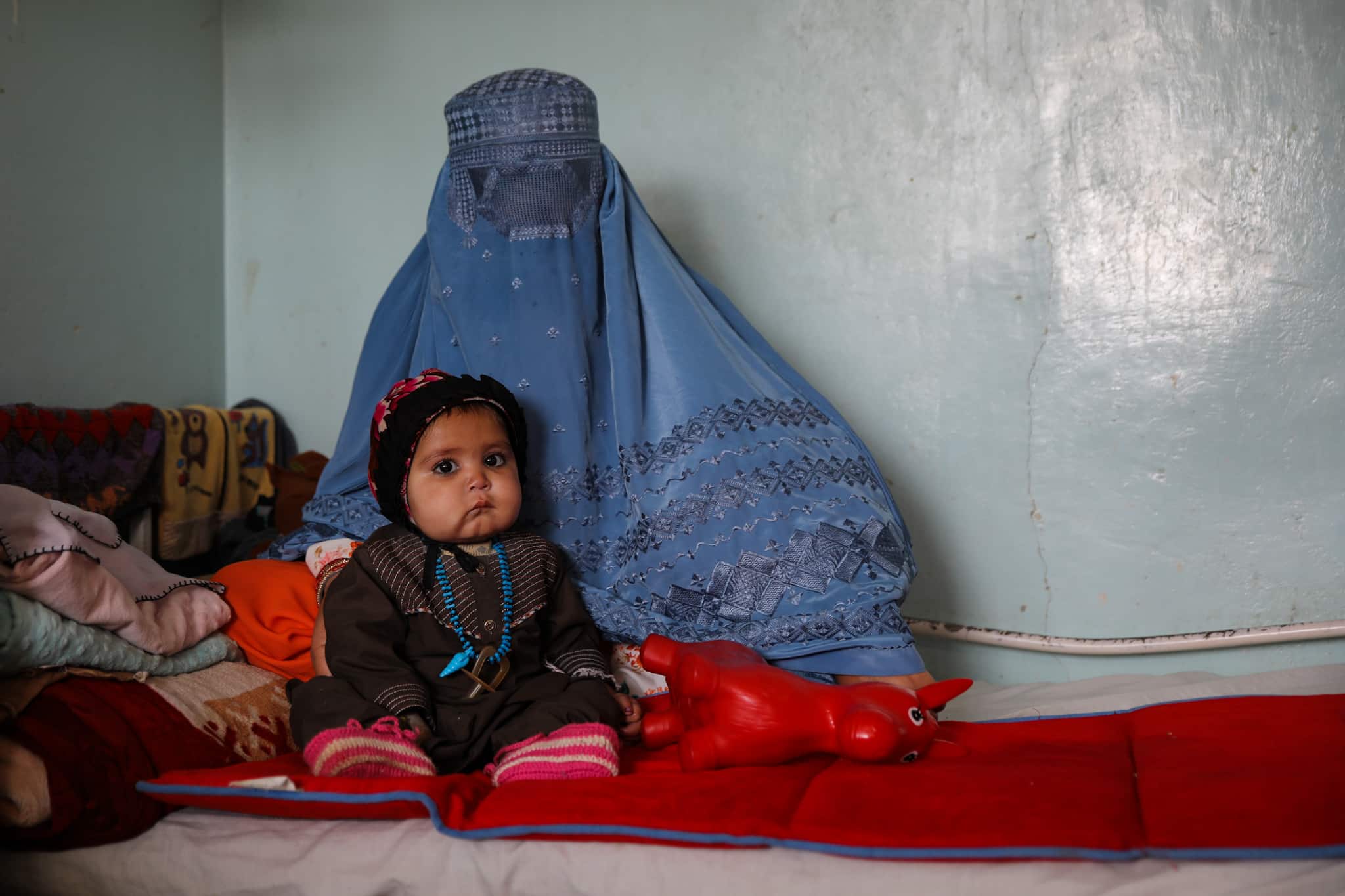 Une femme portant l'habit traditionnel et la burqa, avec son enfant, dans le service de traitement des enfants en malnutrition à l'hôpital Mirwais de Kandahar